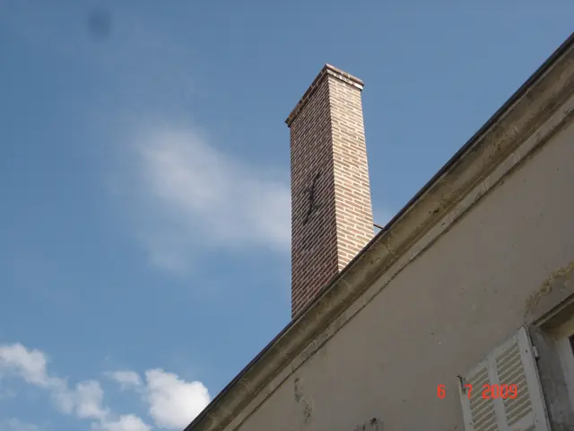 Souche de cheminée en brique sur toiture ardoise, vue d'ensemble
