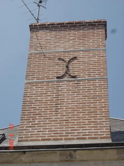 Cheminée en brique rouge avec motif de losange, vue de face