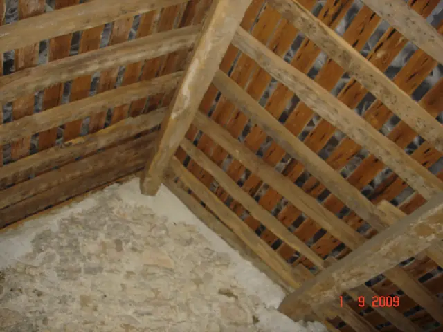Angle de charpente et mur en moellons dans les combles
