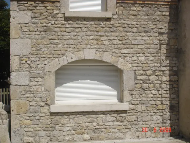Encadrement de fenêtre en pierre de taille sur façade en moellons apparents