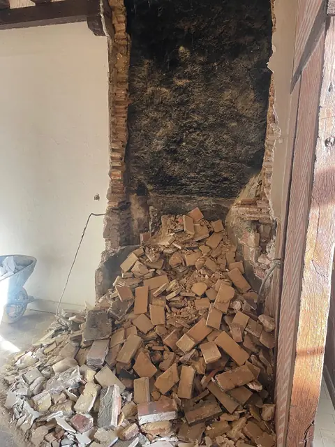 Démolition d'une cheminée en brique lors d'une rénovation intérieure