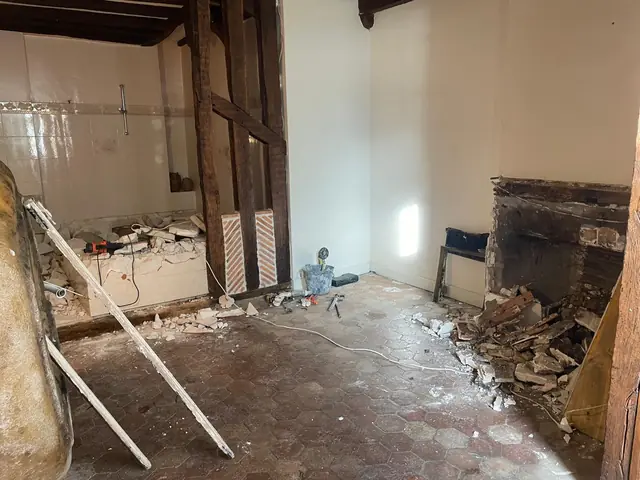 Pièce en cours de rénovation avec colombages et plafond à poutres