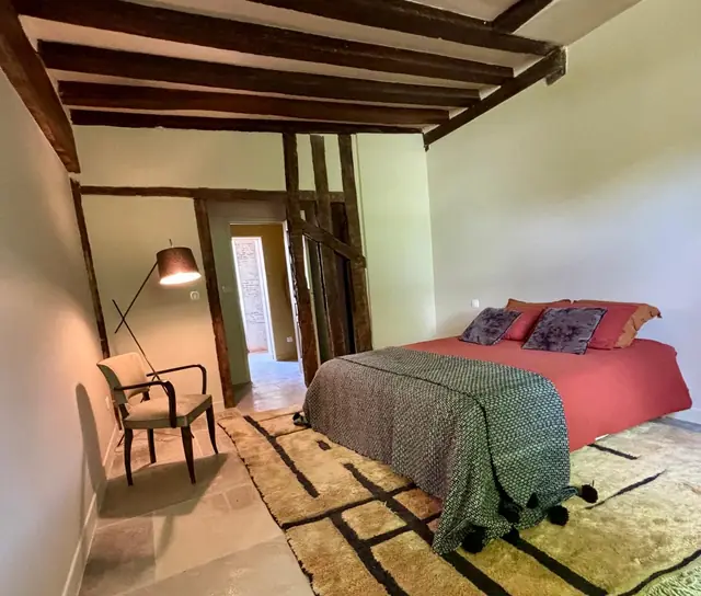 Chambre rénovée avec plafond à poutres et colombages