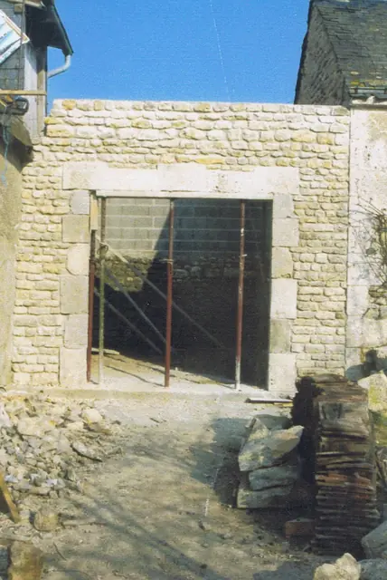Ouverture et encadrement en pierre créés dans un mur de cour