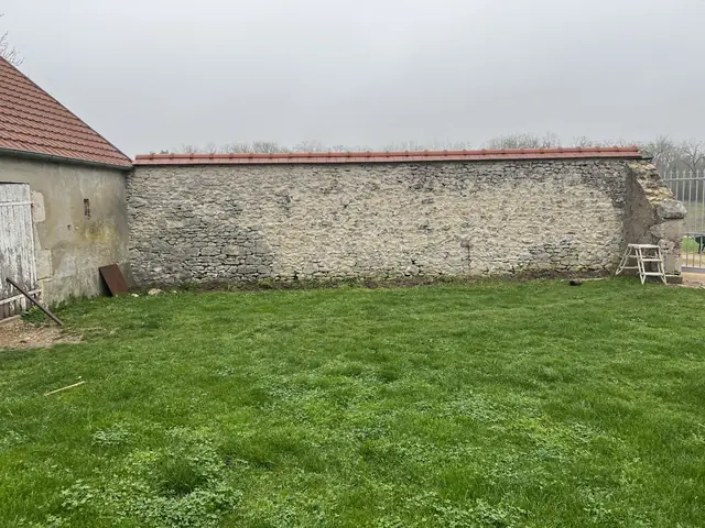 Mur de clôture en pierre avant restauration, jardin en Loir-et-Cher