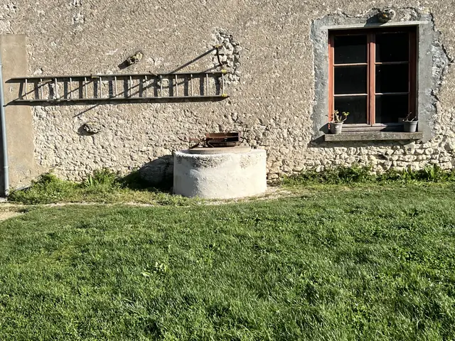 Puits et façade en pierre restaurés avec enduit à la chaux