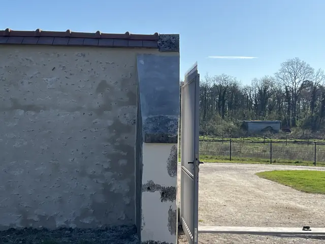 Pilier de portail rénové et mur de clôture enduit