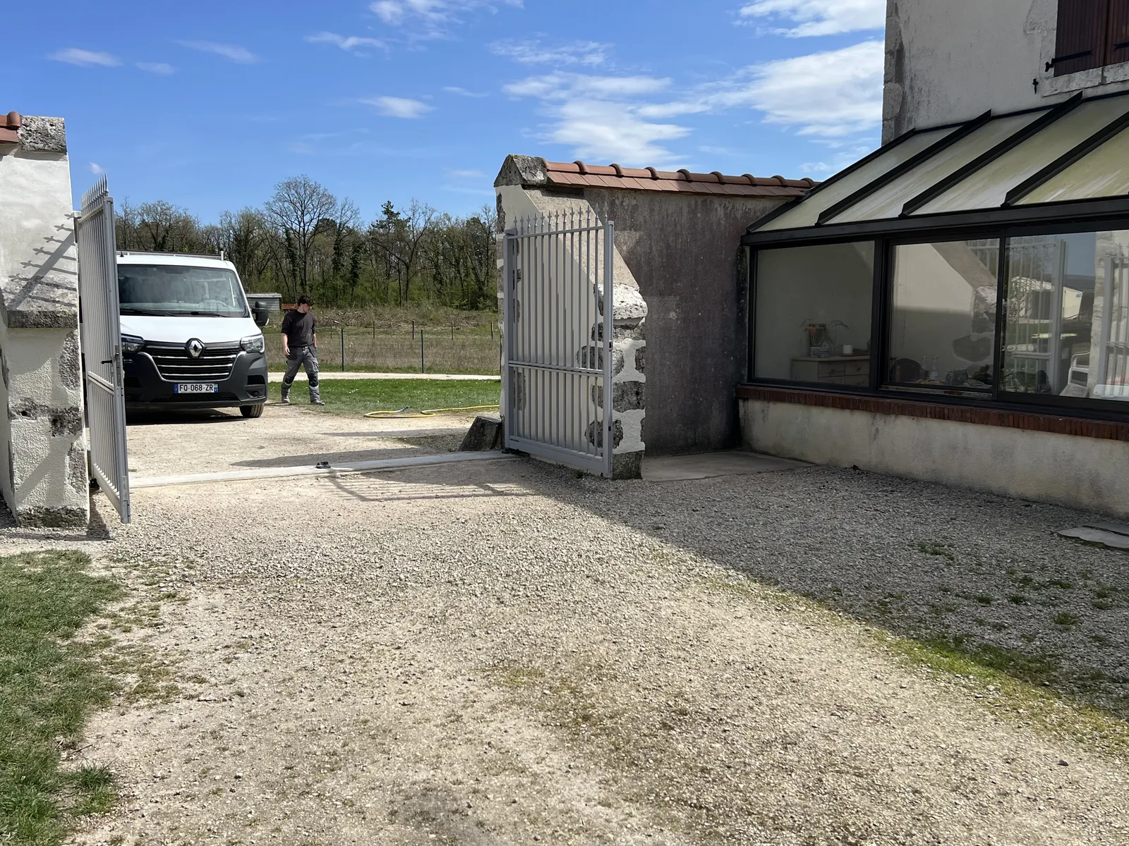 Mur de clôture restauré par Aktibat, véhicule de l'entreprise en arrière-plan